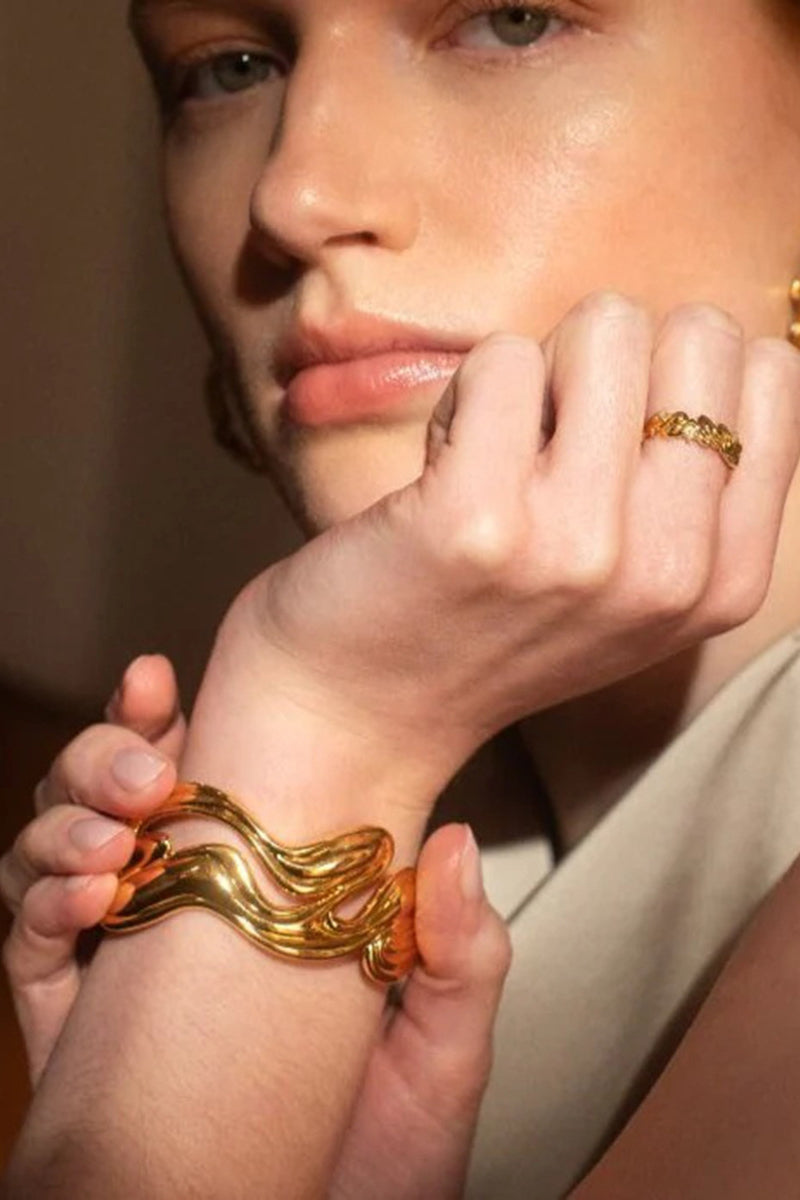 Bracciale rigido aperto scultoreo in oro
