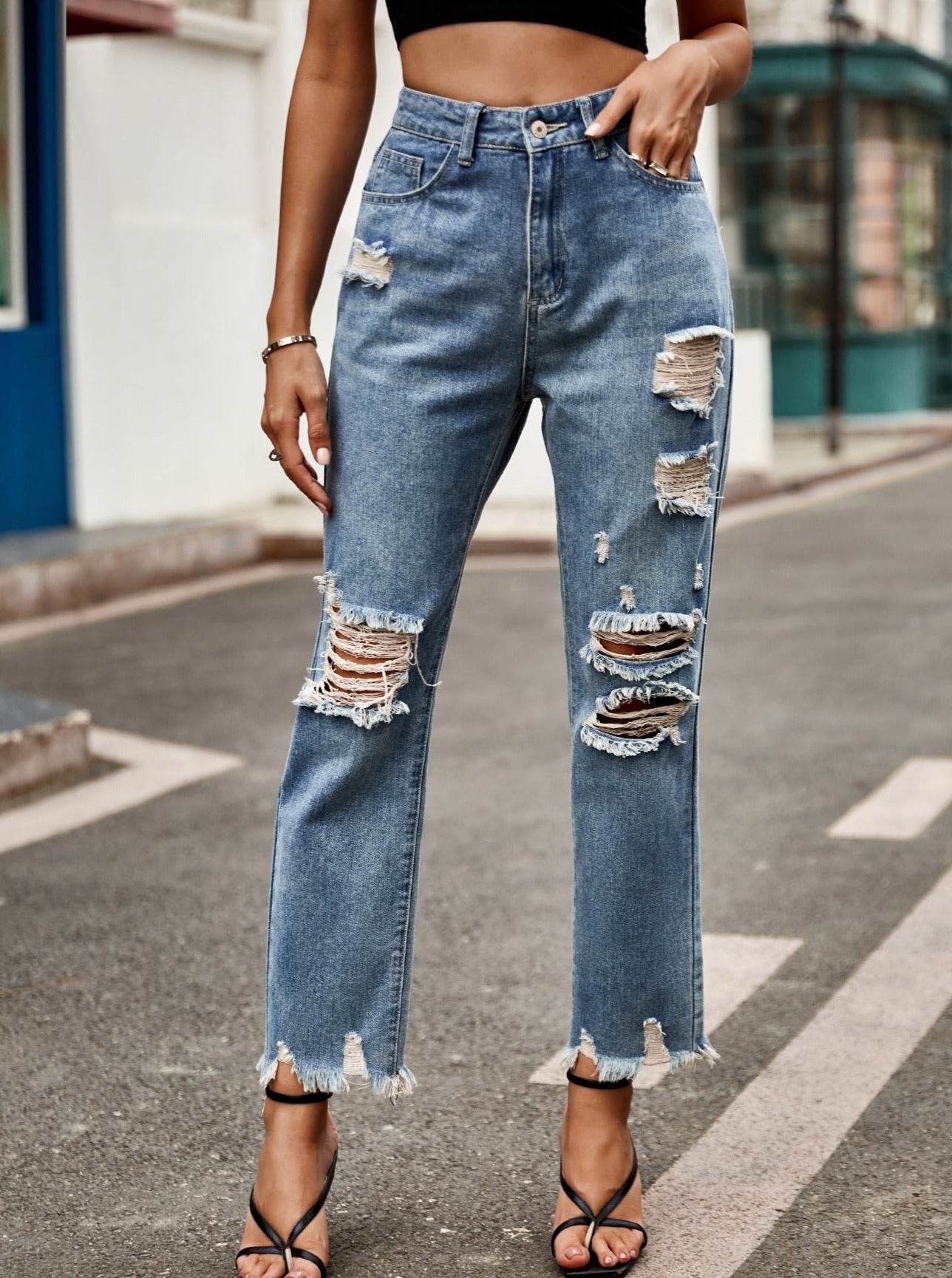 Jeans in denim svasato strappato con bottoni a vita alta