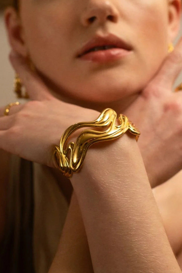 Bracciale rigido aperto scultoreo in oro